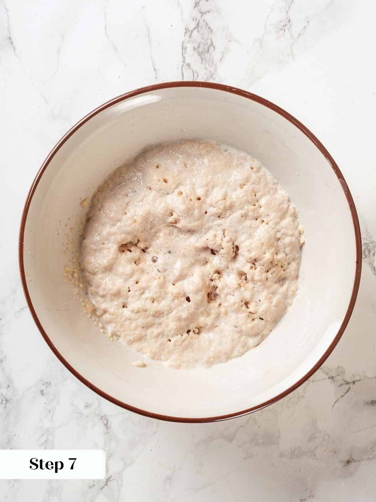 A small bowl of bloomed yeast, foamy and active for bread making.