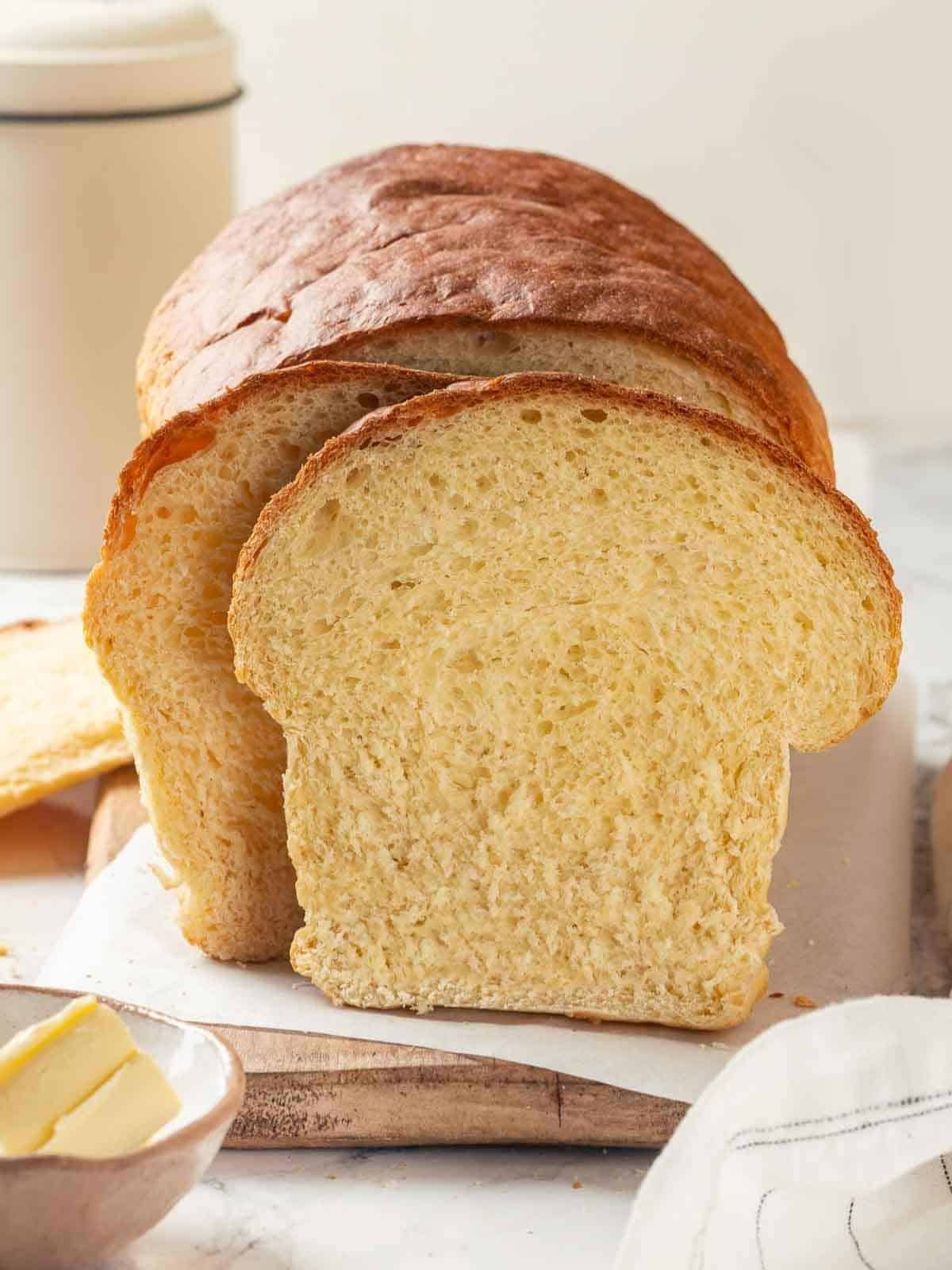 A loaf of potato bread partially sliced, showing its soft interior and golden crust.