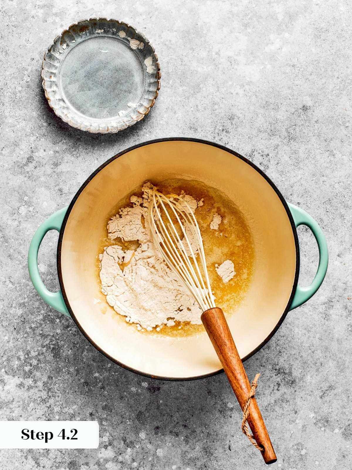 Flour being stirred into a pan of butter to start the mac and cheese sauce.