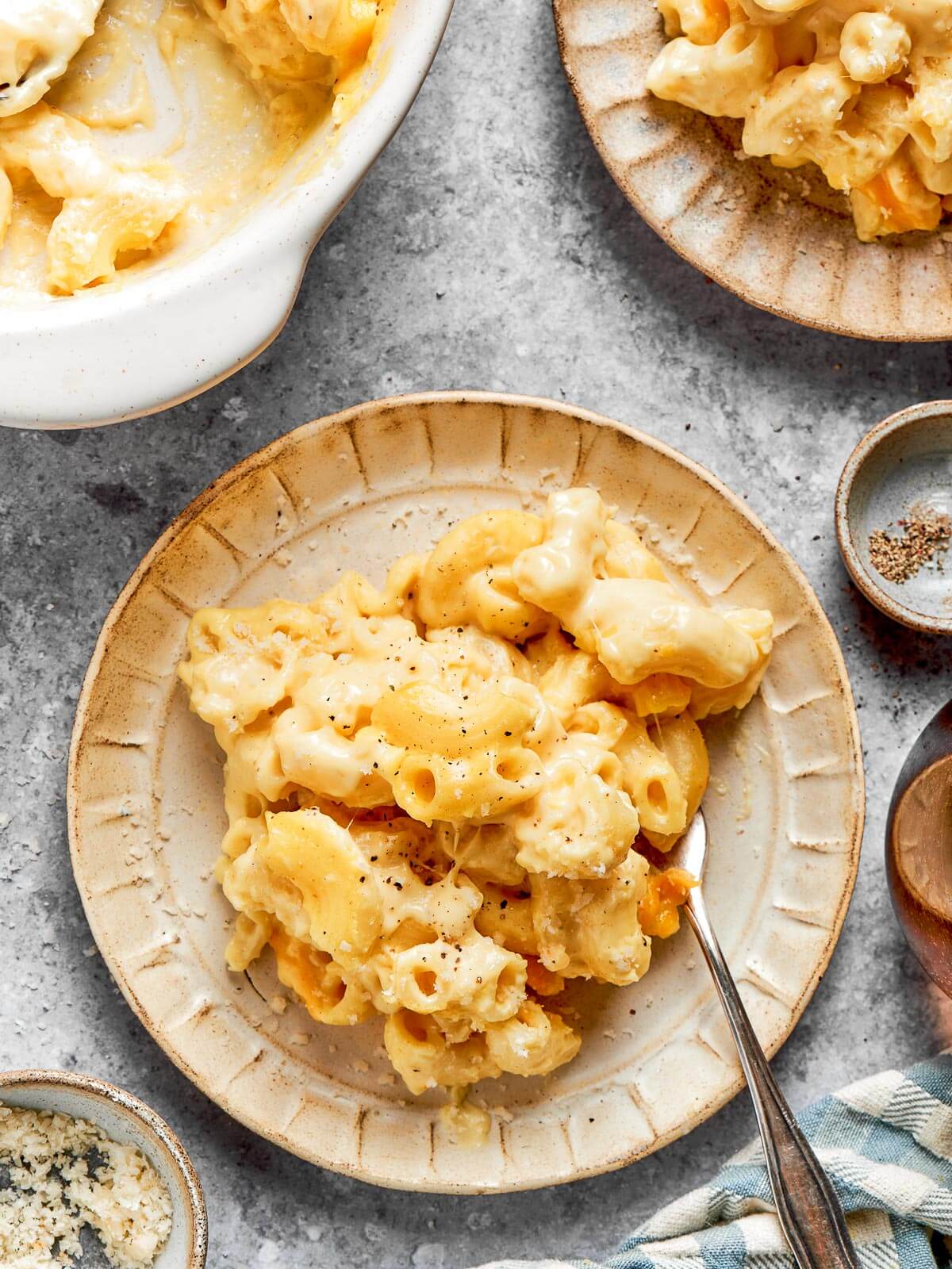A plate of cheesy mac and cheese sitting on a countertop.