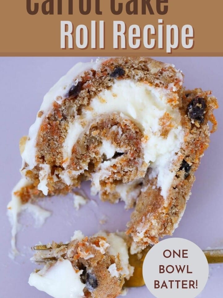 Rolled carrot cake sliced on a plate with cream cheese frosting inside.