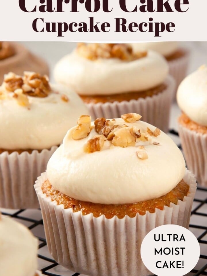 Close-up of frosted carrot cake cupcakes with crushed walnuts on top.
