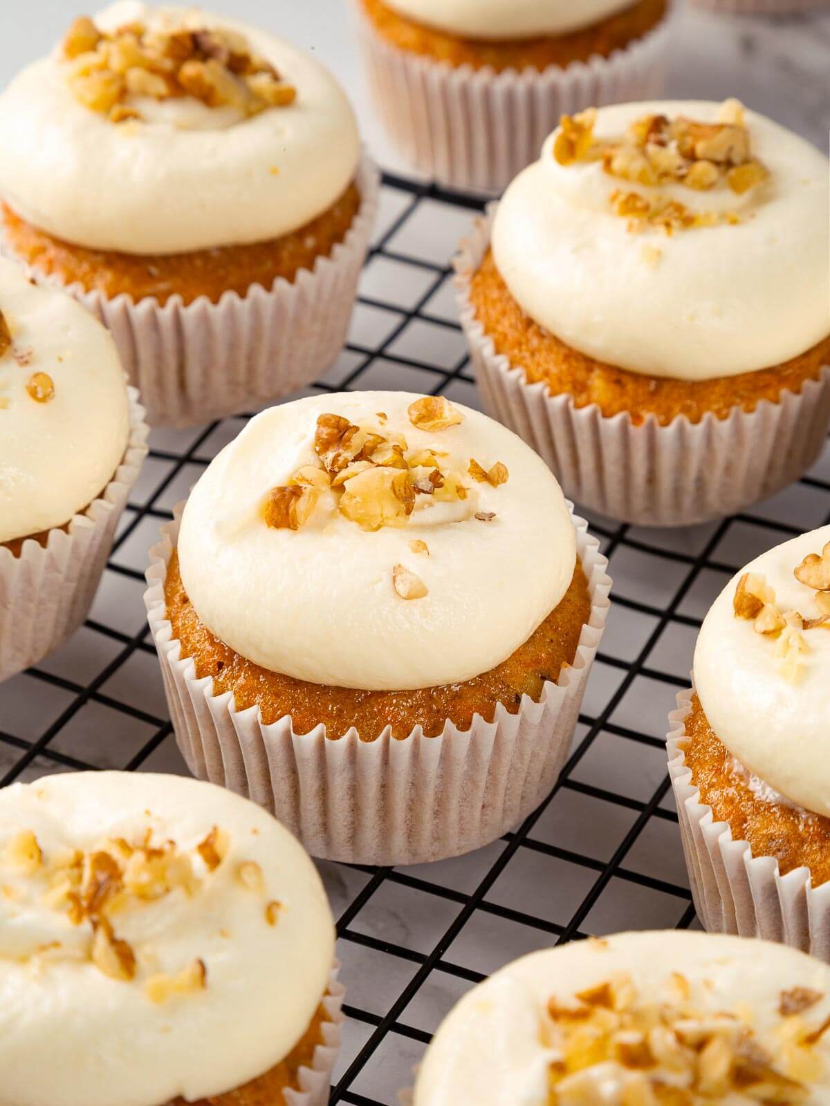 Frosted carrot cupcakes with smooth cream cheese topping.