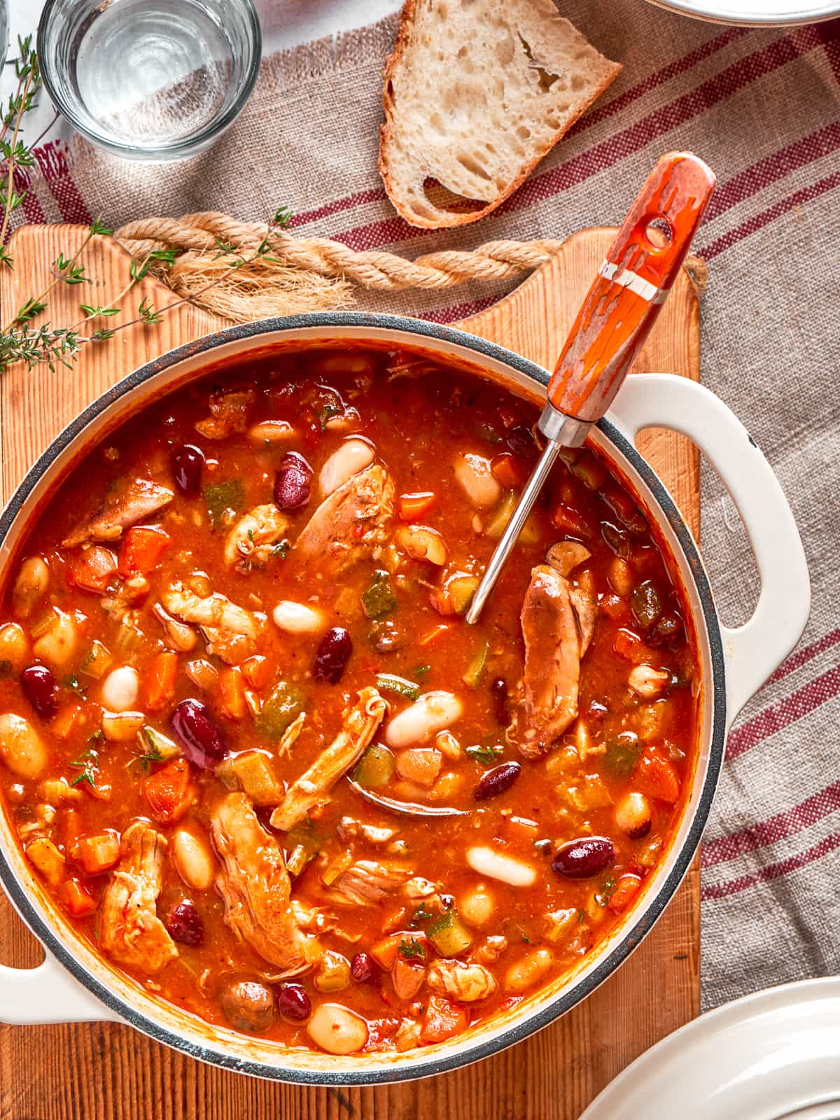 Chicken vegetable soup with a rich red broth.