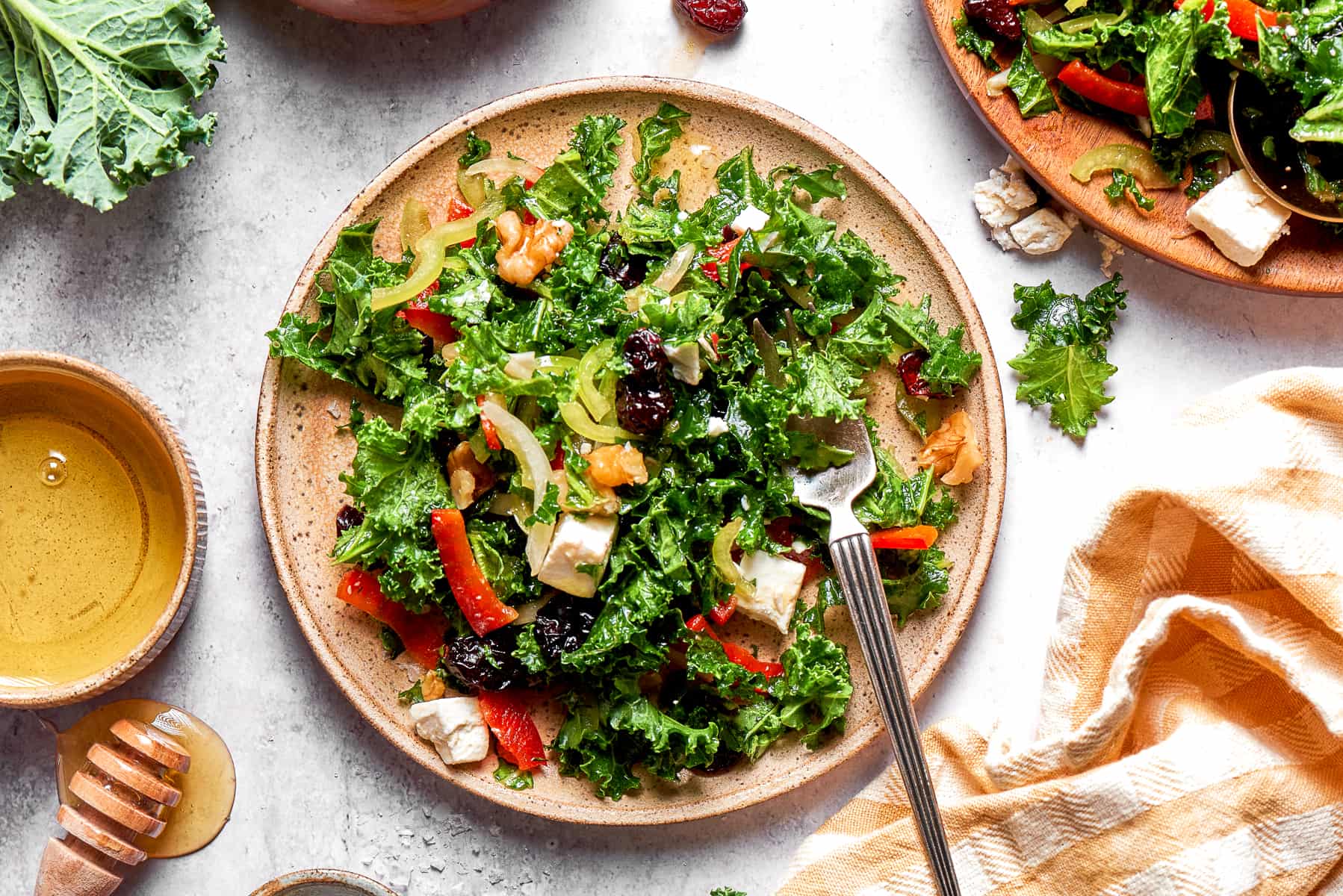 A plate of kale salad set beside a cloth napkin.