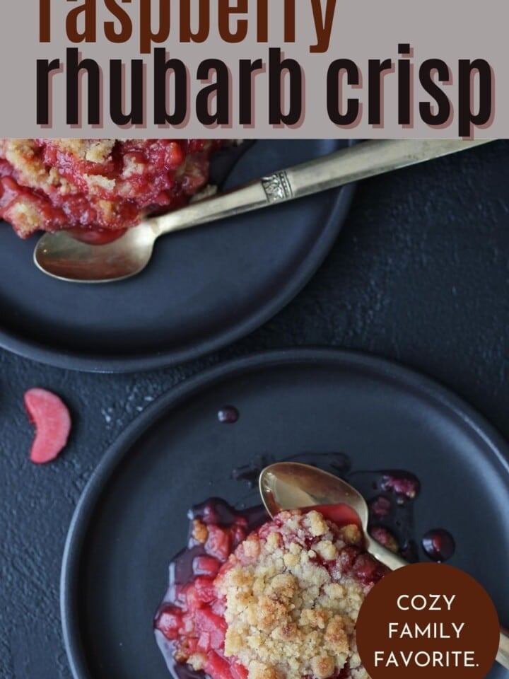 A close-up of bubbling raspberry rhubarb crisp showing thick fruit and crispy edges.