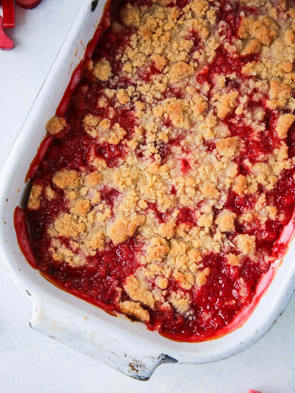 Full white baking dish of strawberry rhubarb crumble fresh from the oven.