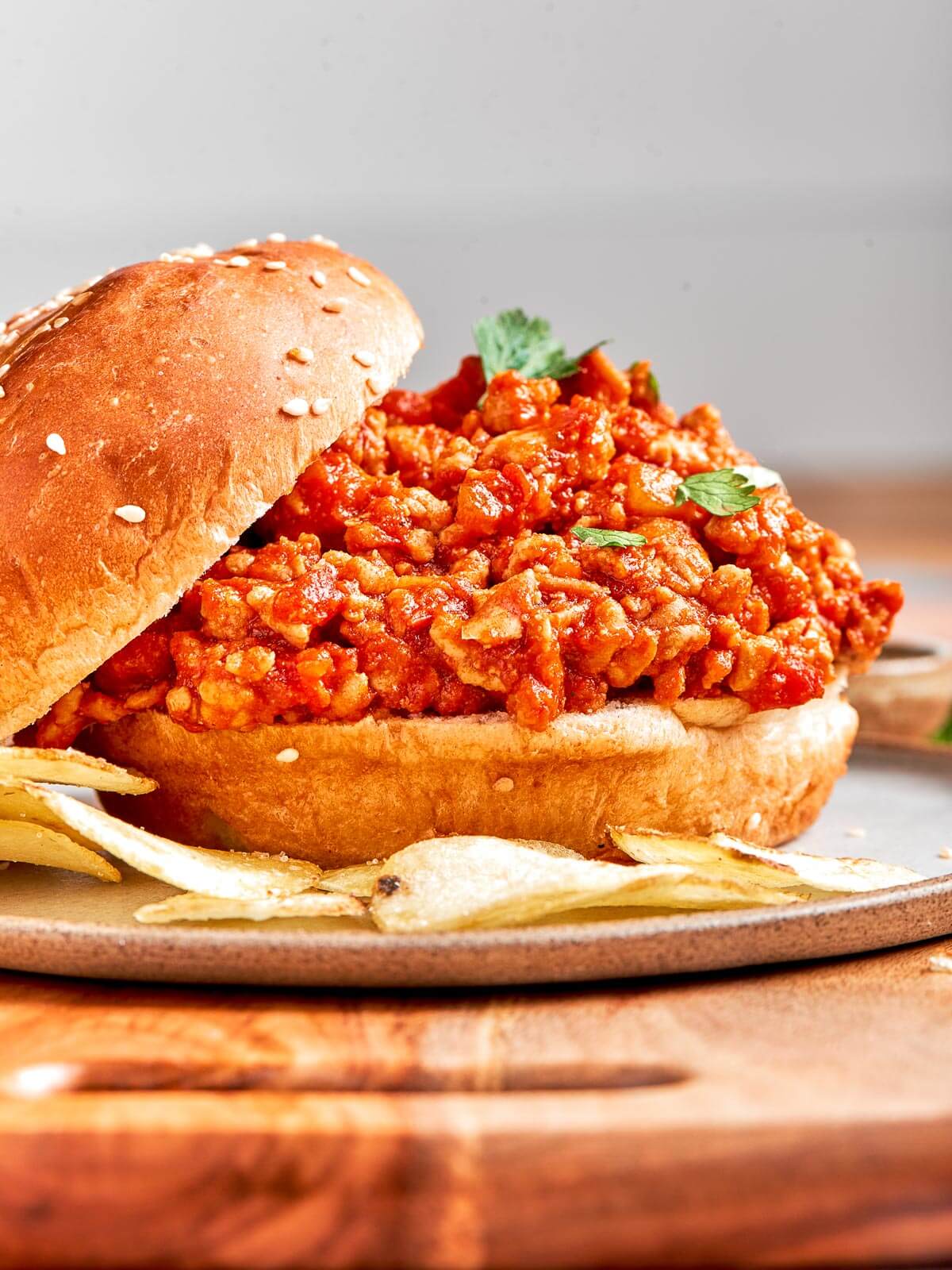 A hearty helping of turkey sloppy joe filling spilling out of a soft bun.
