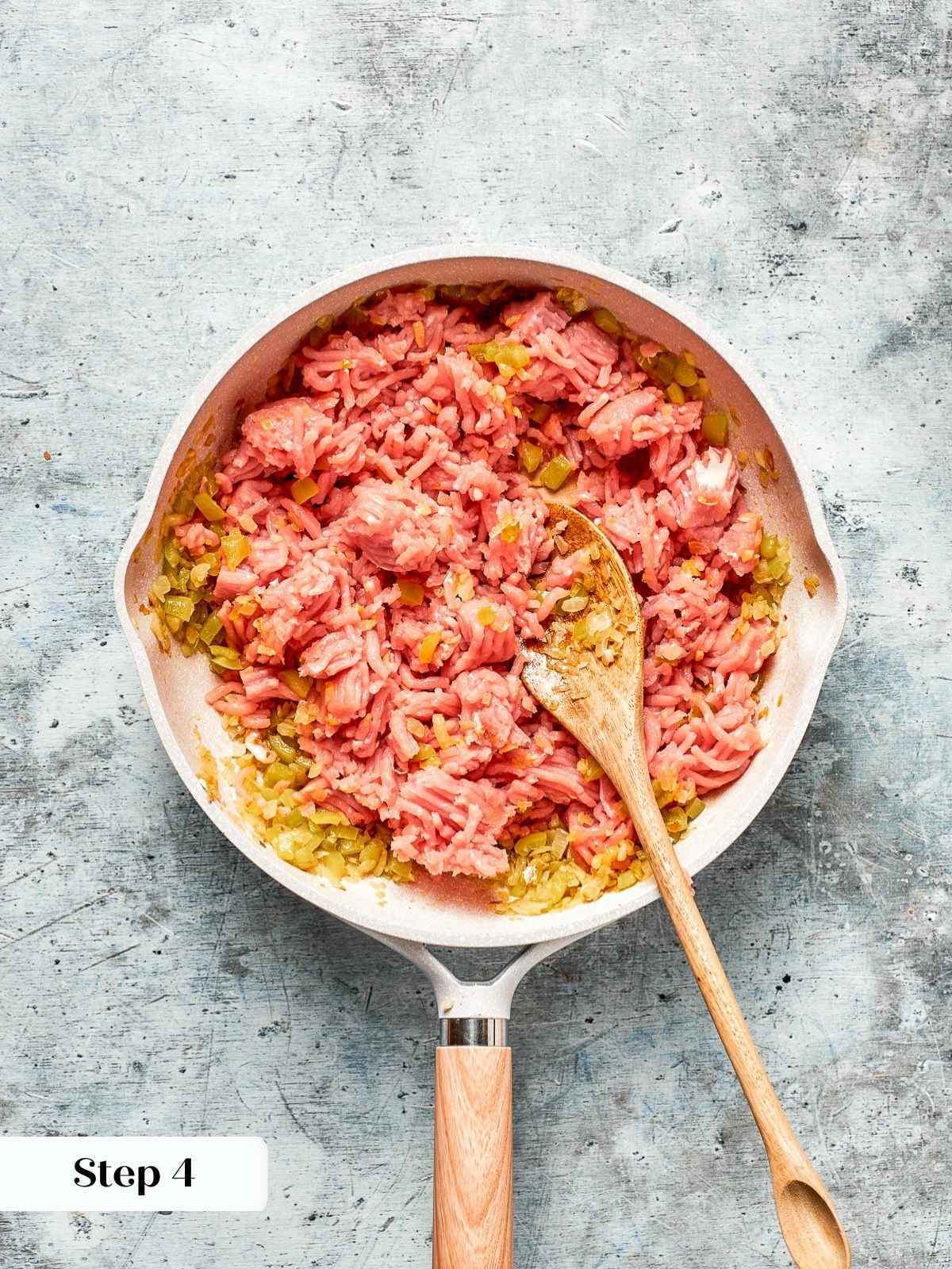 Breaking up the turkey meat with a spoon while cooking.