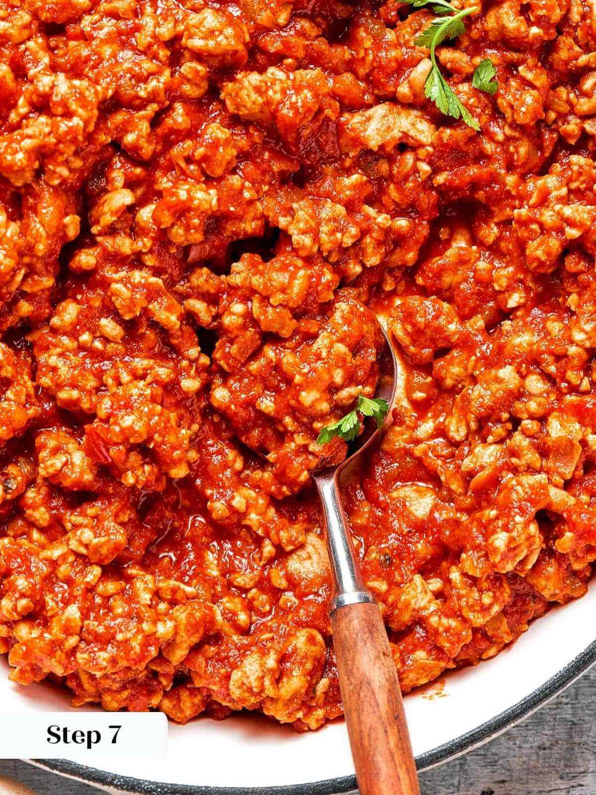 A spoon scooping up the saucy turkey sloppy joe mixture.