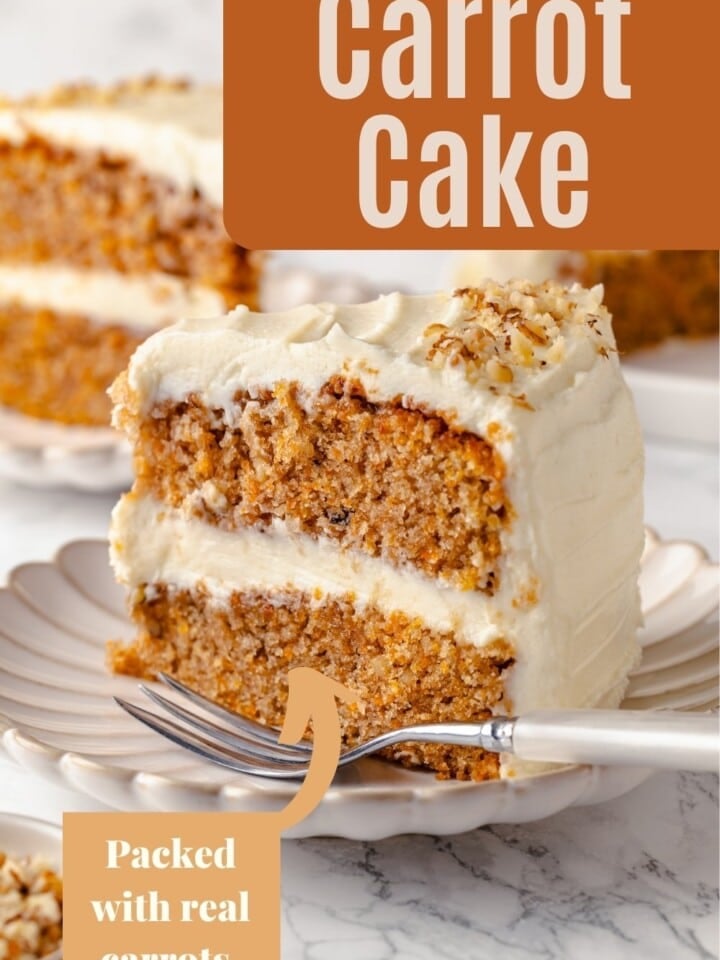A slice of moist carrot cake topped with thick cream cheese frosting.
