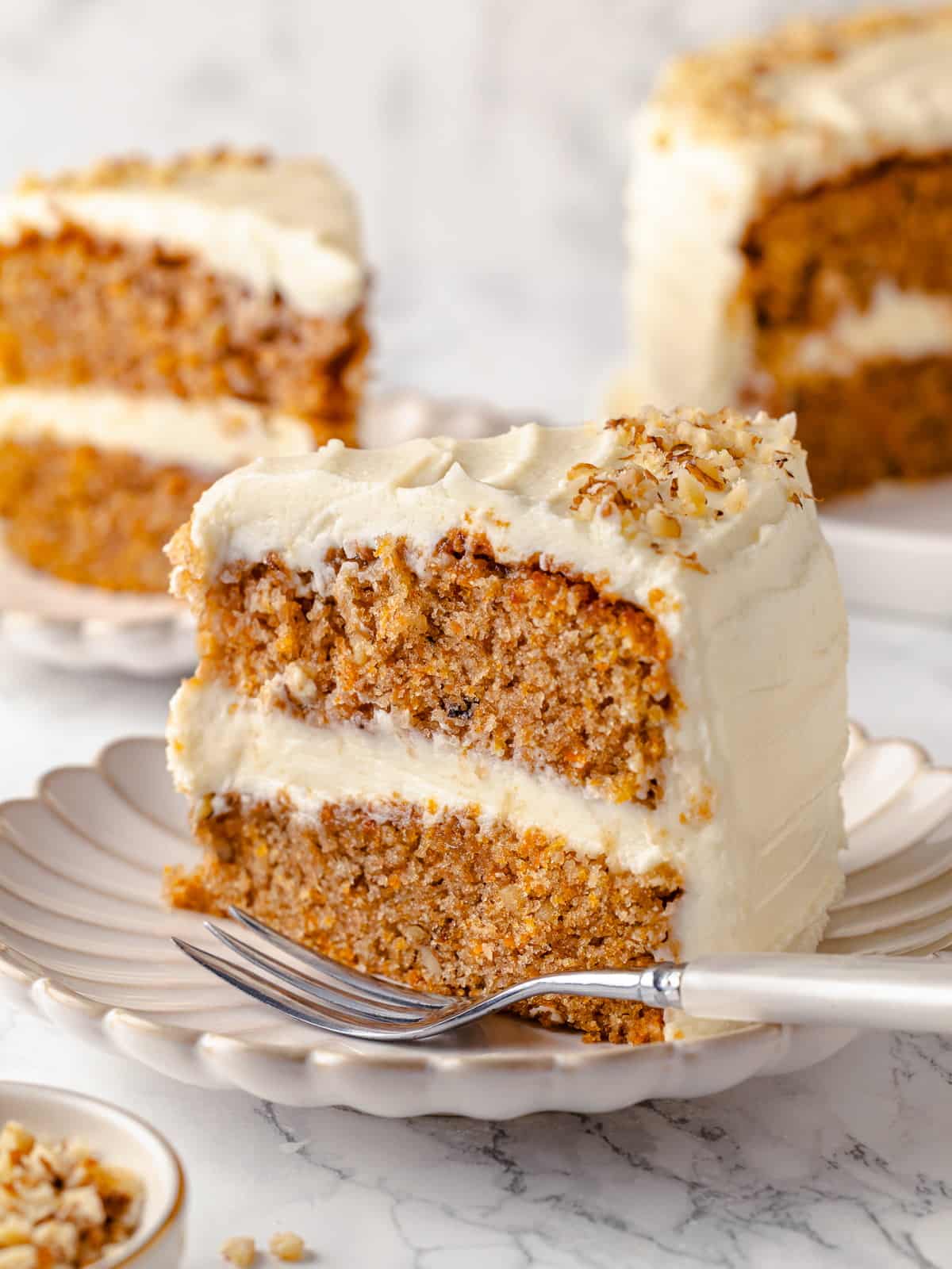 Interior view of slice of carrot cake with cream cheese frosting.