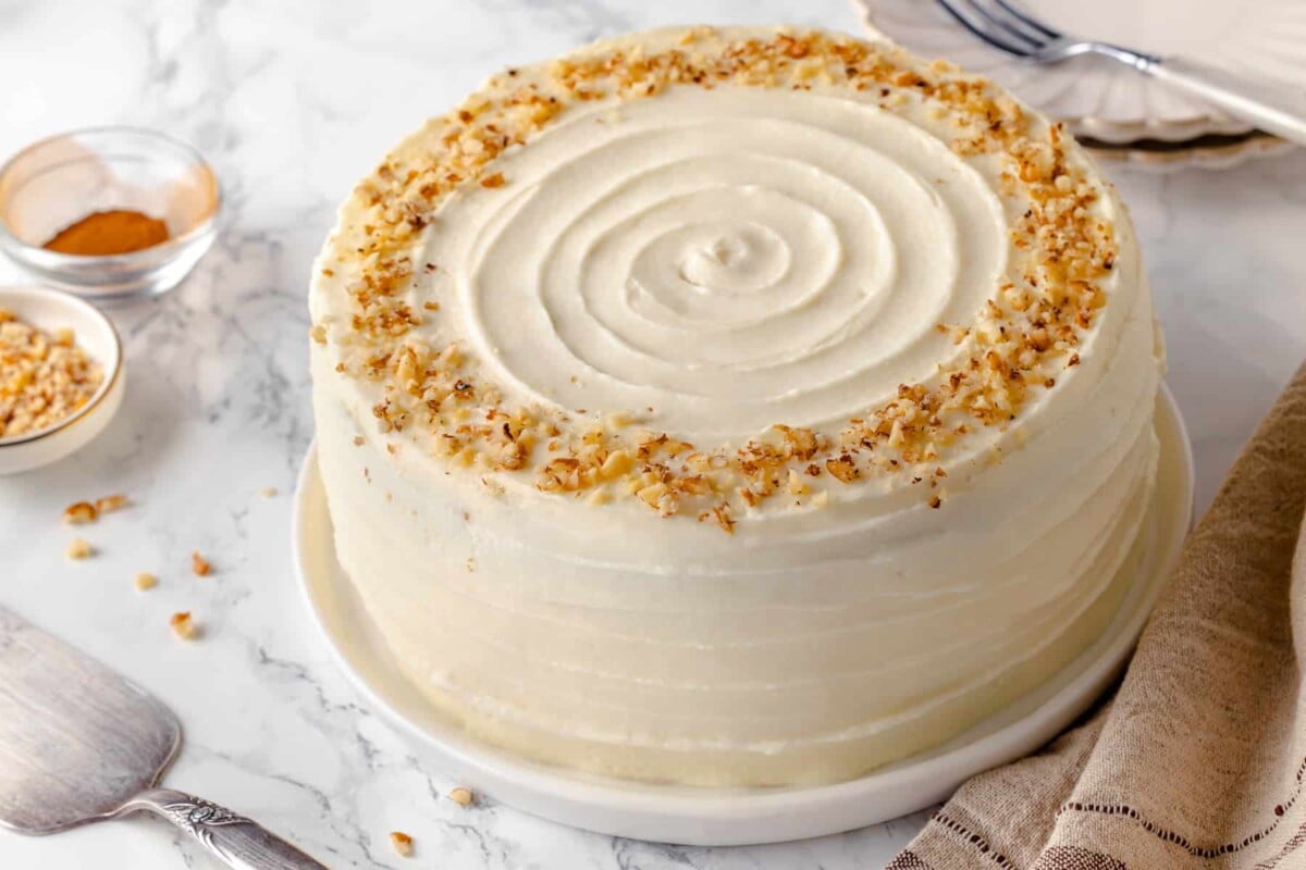 Frosted carrot cake with clean swirl top.