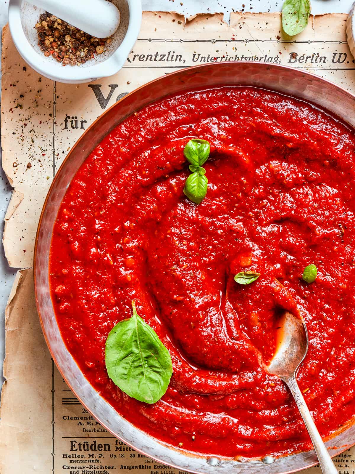 A pan of finished pizza sauce with a swirl pattern on top.