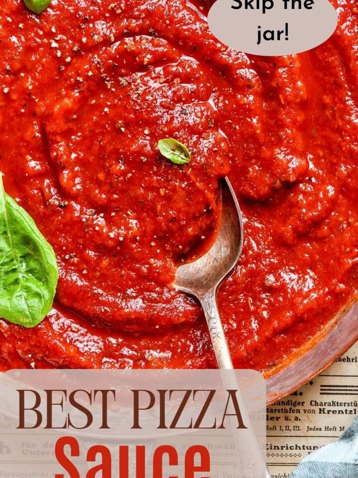 Pizza sauce swirled in a bowl with herbs on top.