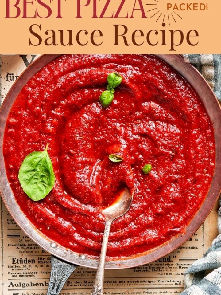 Cooked pizza sauce cooling in a pan beside a kitchen towel.
