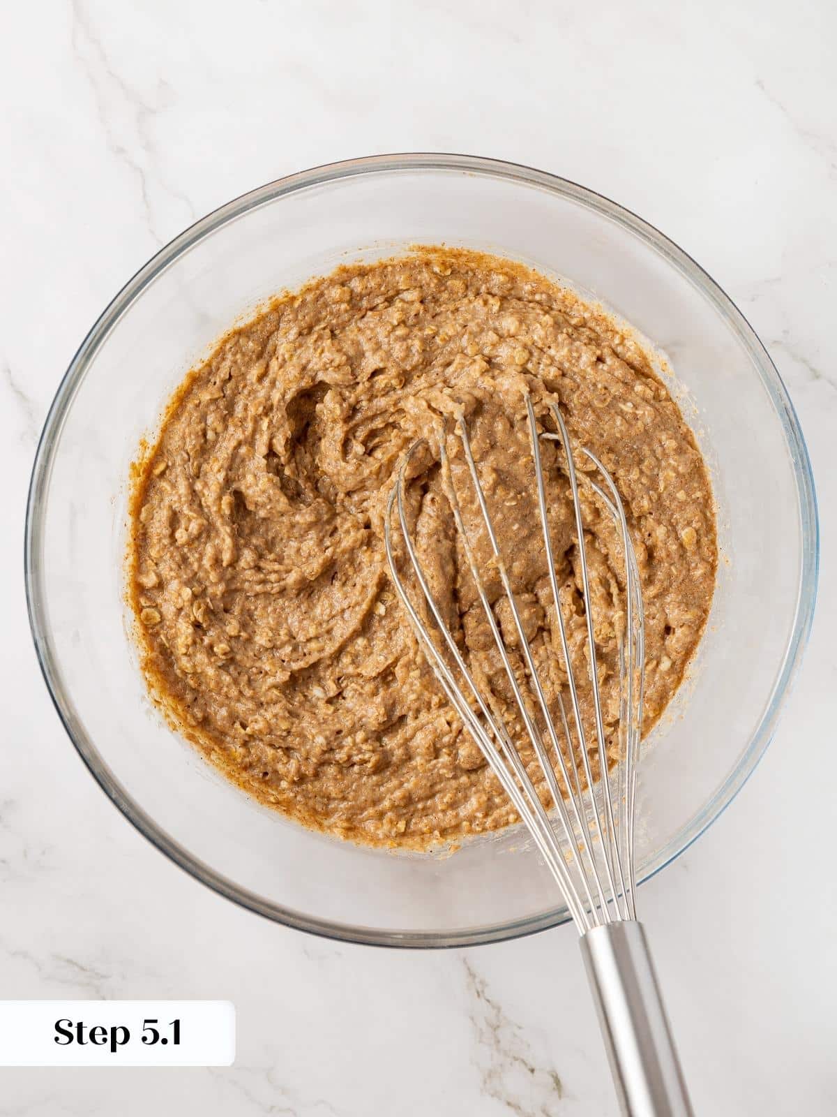 Combining flour mixture with wet ingredients in a mixing bowl.