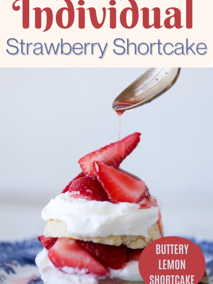 Individual strawberry shortcake on a blue plate with sliced fresh strawberries.