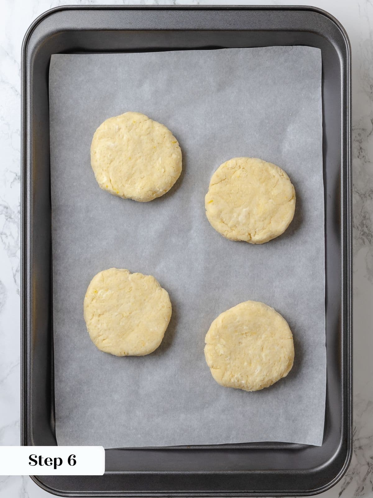 Biscuit dough rounds on a baking sheet after chilling.
