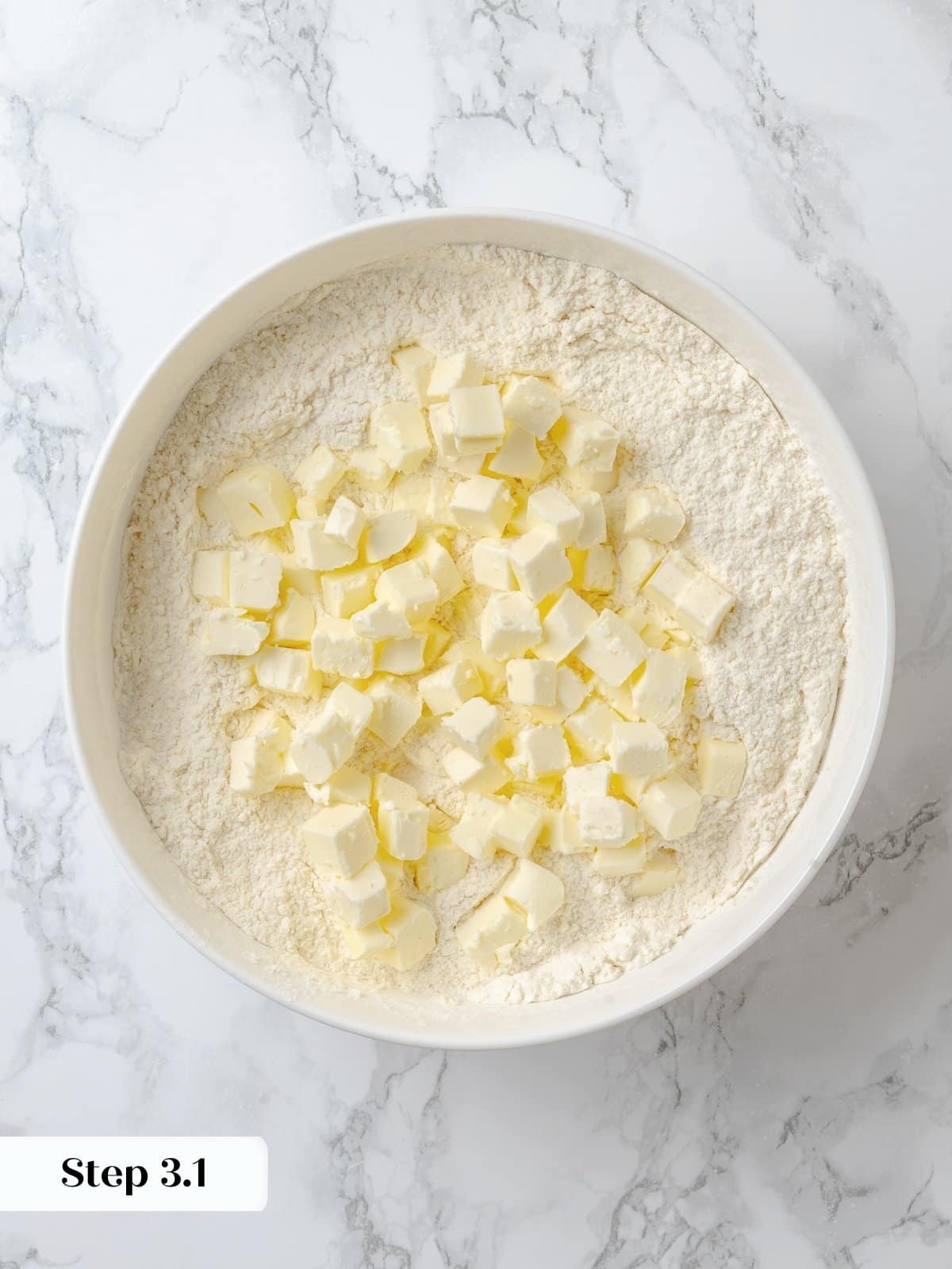 Incorporating cold butter into dry ingredients to start the shortcake dough.