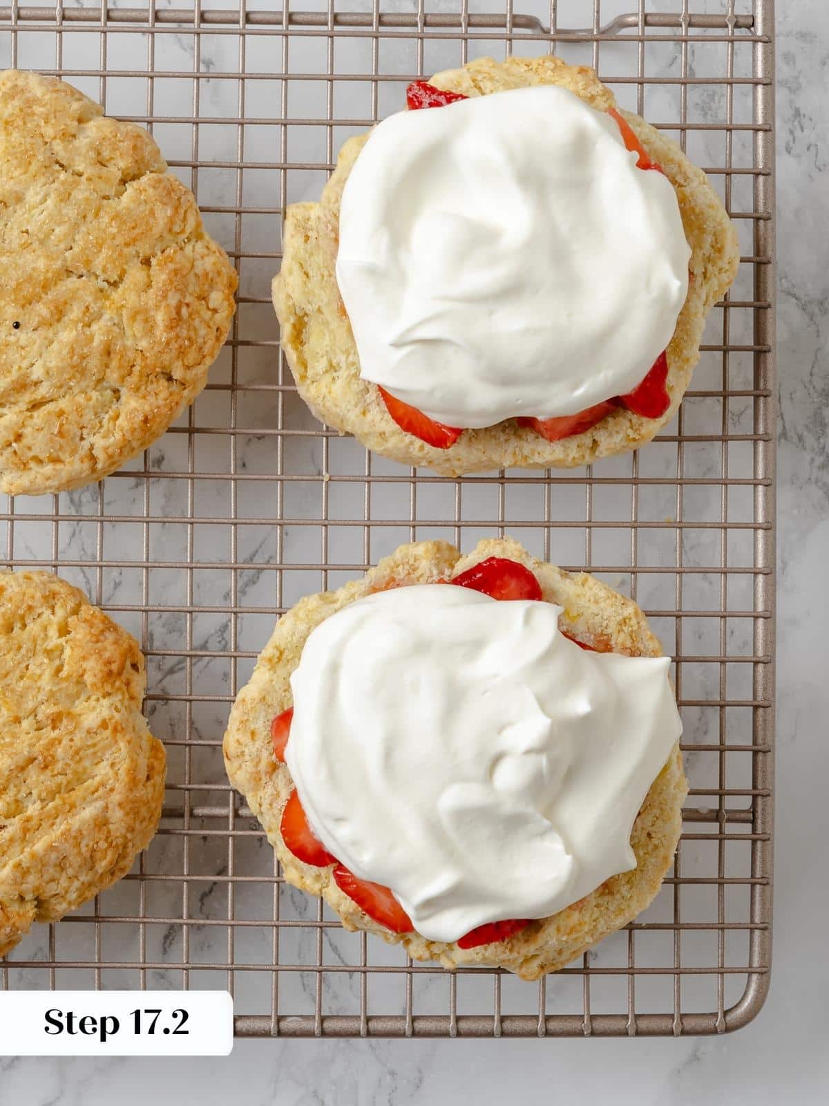 Shortcake halves filled with whipped cream and ready to be topped.