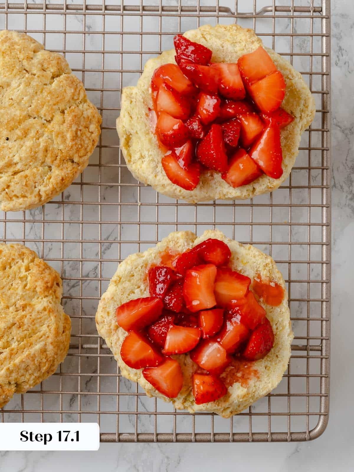 Fresh strawberries layered over shortcake biscuits in the assembly stage.
