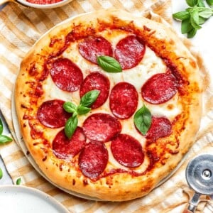 Close-up of golden, crisp crust on baked pepperoni pizza.