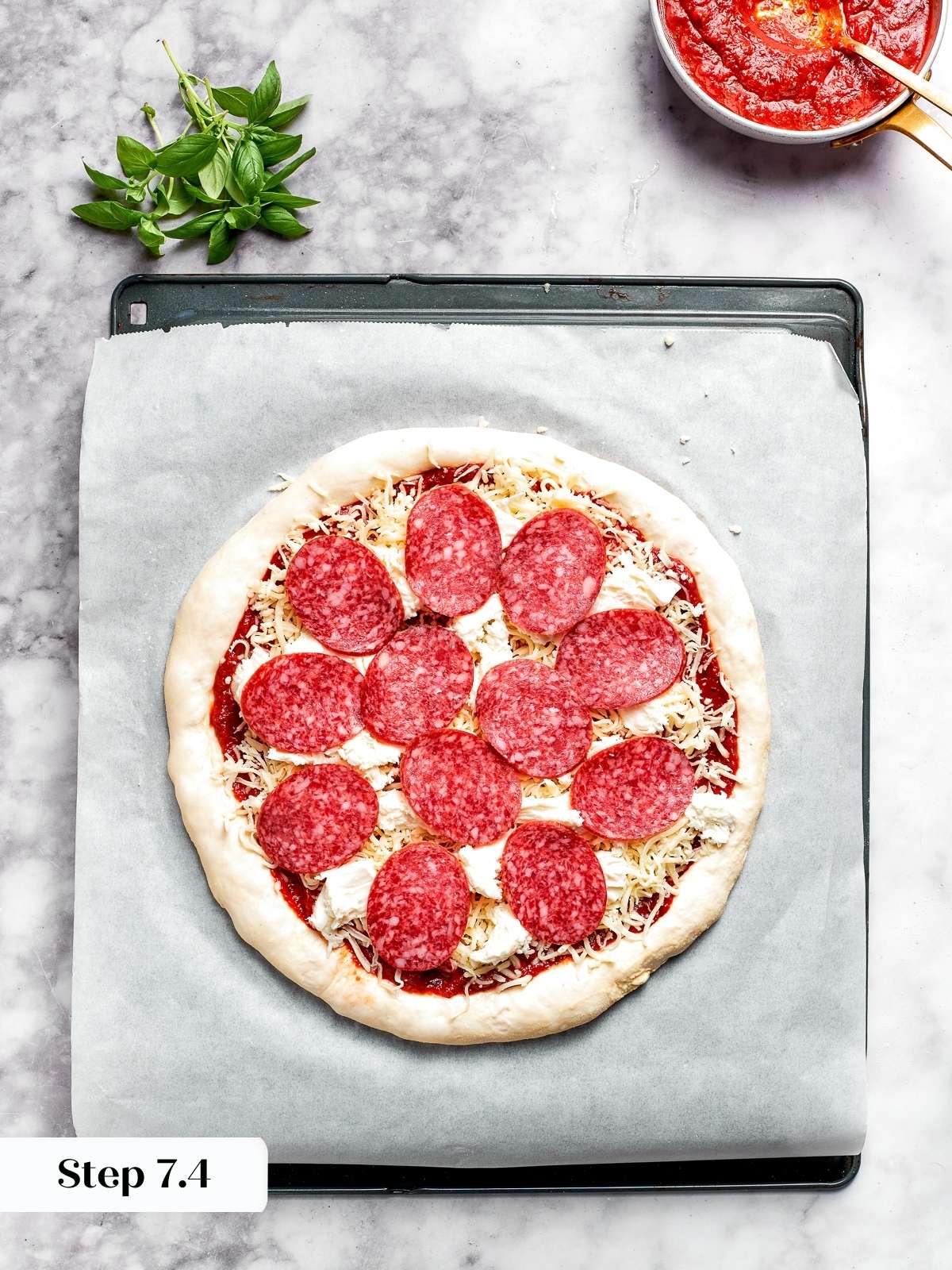 Arranging pepperoni slices on top of the cheese layer.