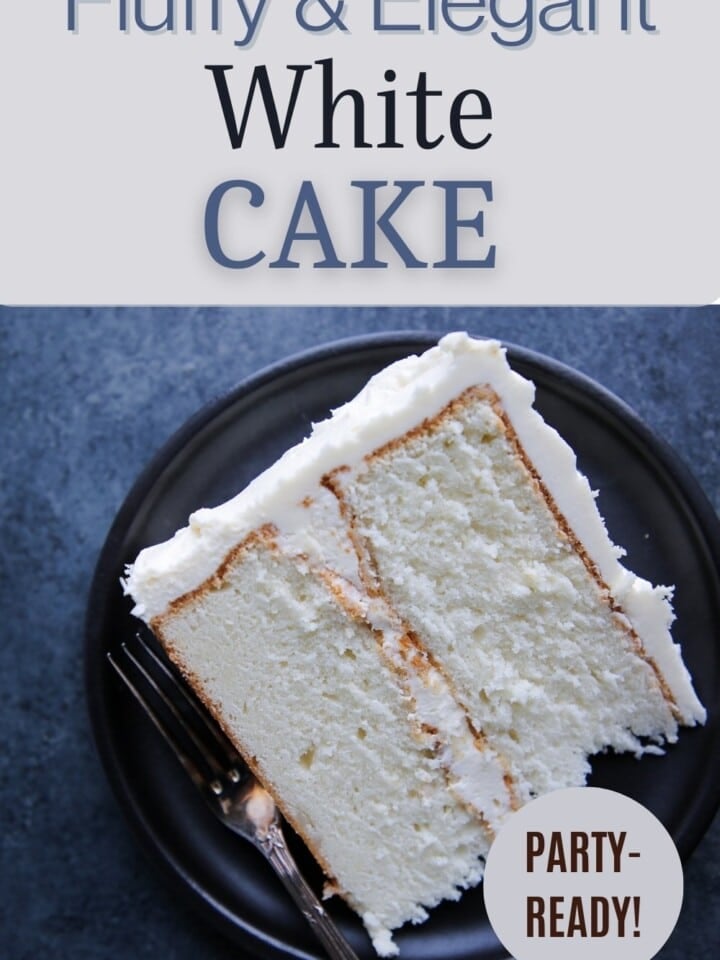 A slice of white cake with smooth buttercream frosting on a black plate.