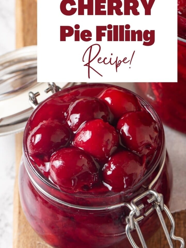 Glass jar packed with homemade cherry pie filling, with vibrant red syrup showing through.