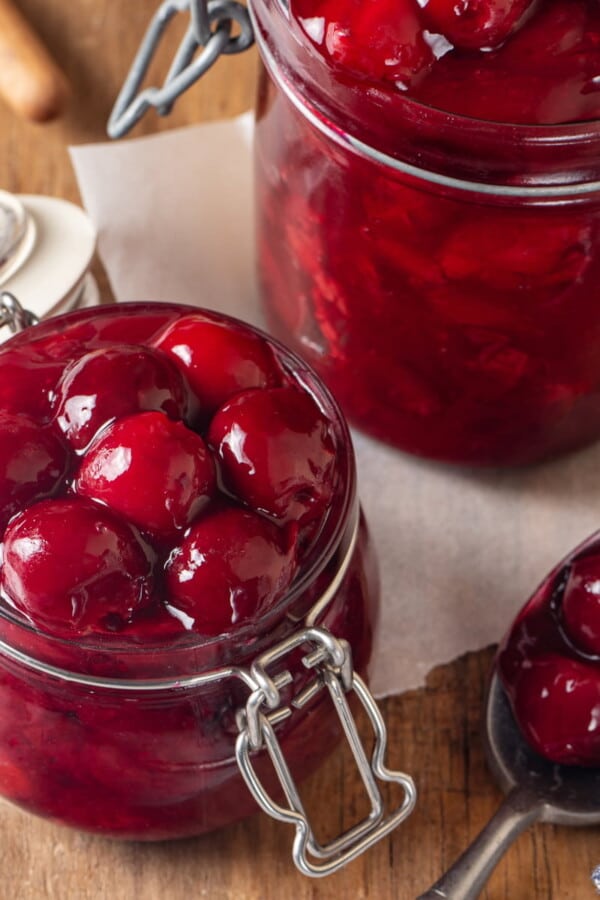 Syrupy cherry filling in a jar showing glossy, smooth texture and dark red color.
