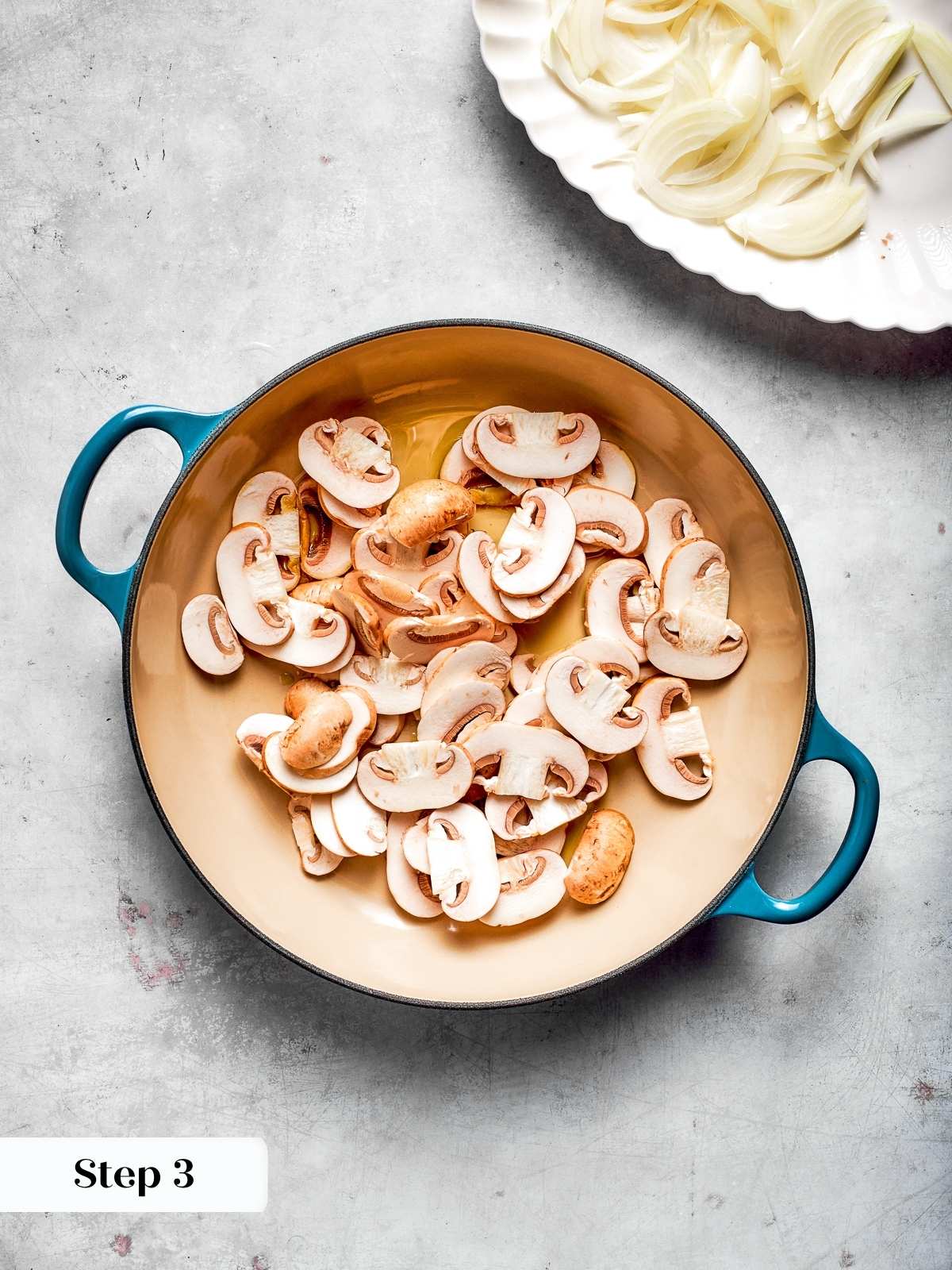 Mushrooms cooking in hot oil, taking on color and softening in the skillet.