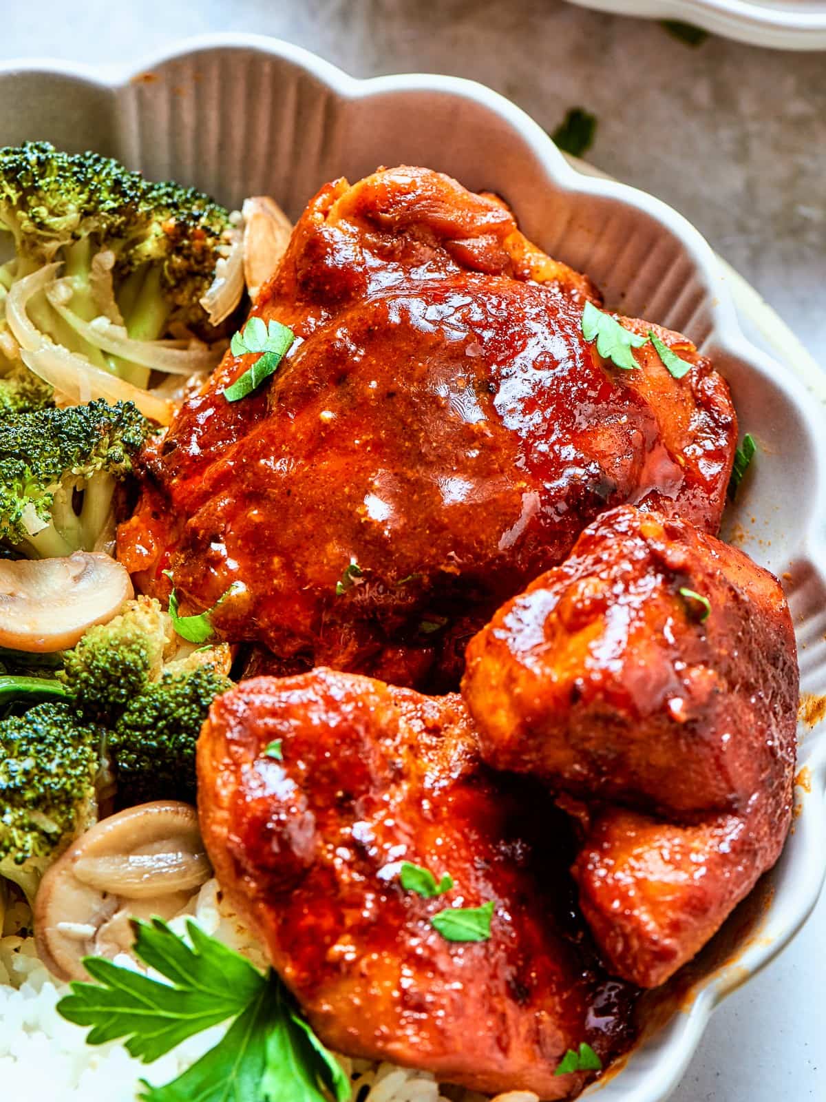 Bold red gochujang sauce in a bowl with browned chicken and softened onions.