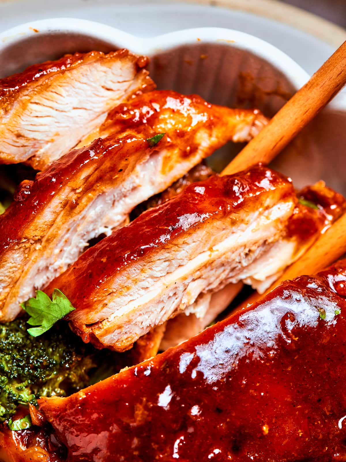 Chicken breasts and thighs sliced after cooking, covered in red sauce and plated.