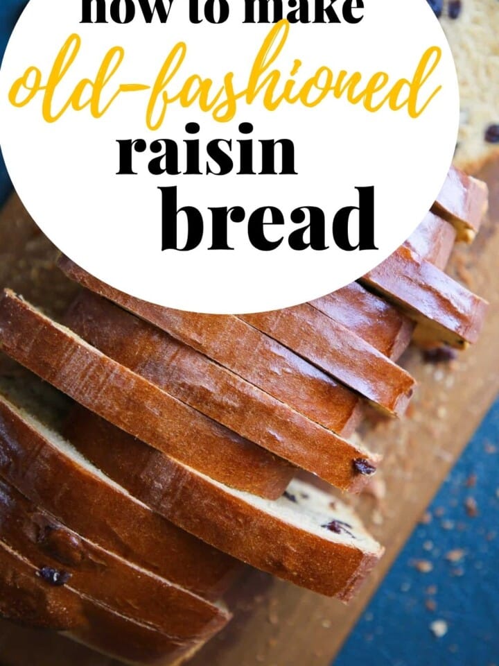 Rustic raisin bread with a glossy crust and soft crumb sliced and stacked sideways on a cutting board.