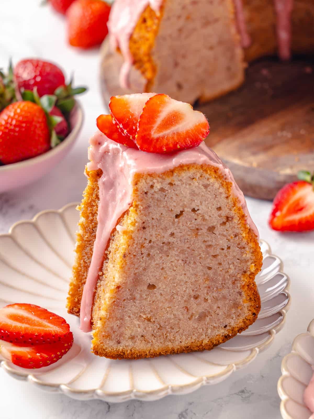 Single slice of strawberry pound cake served with visible glaze drizzle.