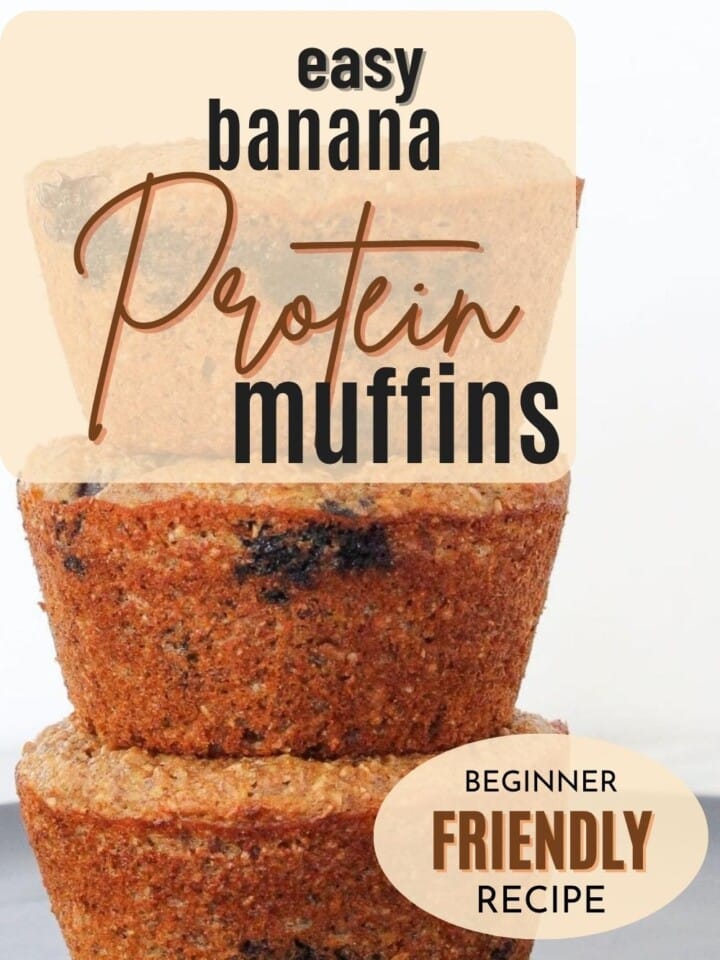Moist banana muffins with golden tops and specks of blueberries stacked.