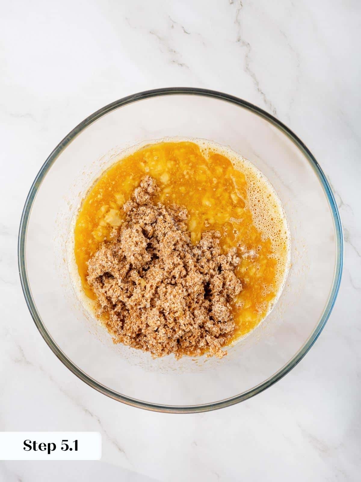 Wet muffin ingredients combined as buttermilk bran blend is added to banana, eggs, and oil.
