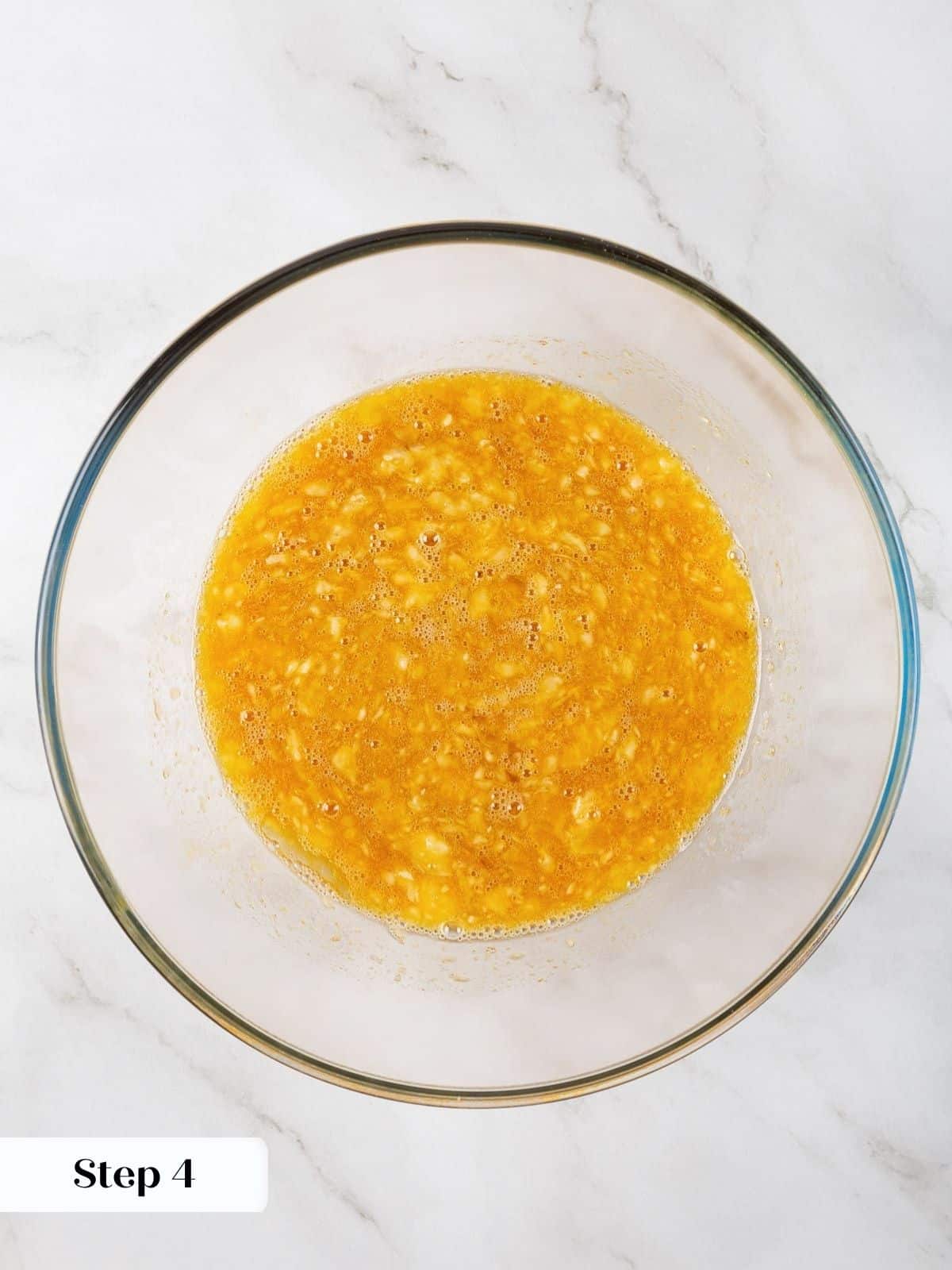 Mixing wet ingredients including eggs and banana in preparation for healthy banana protein muffins.