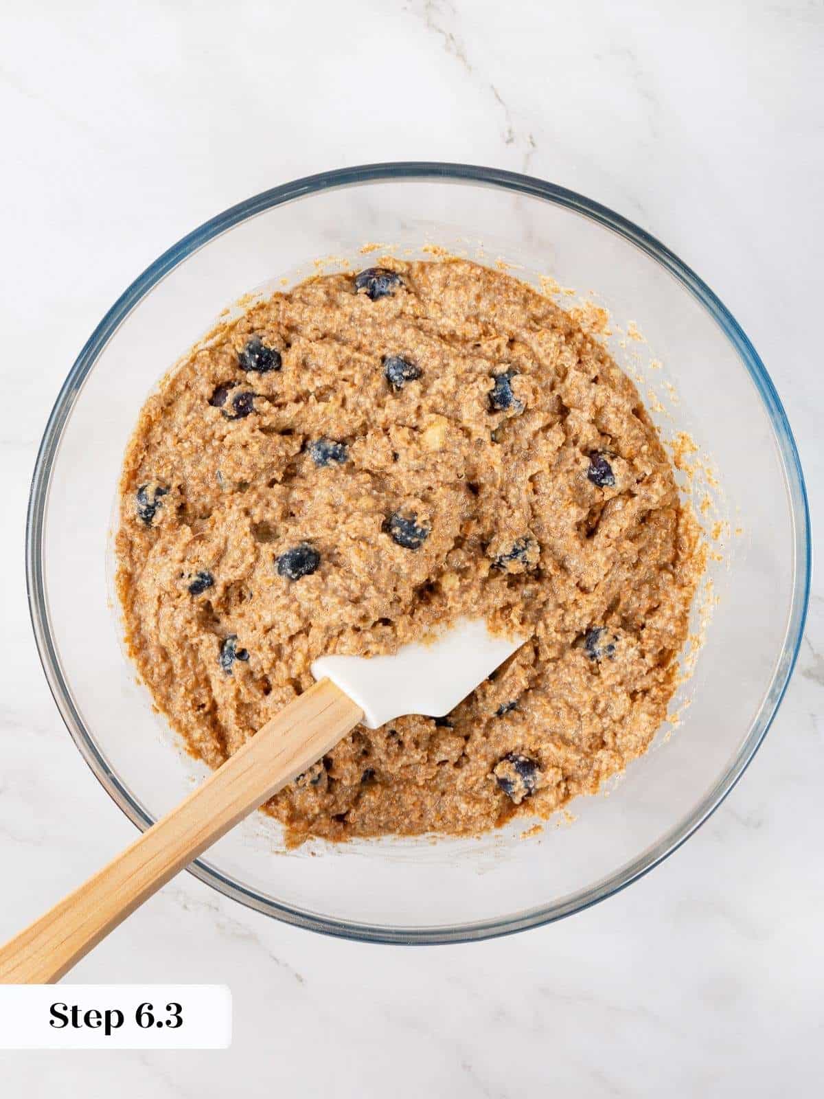 Thick, lumpy muffin batter with visible blueberries and bran, freshly mixed and ready to bake.