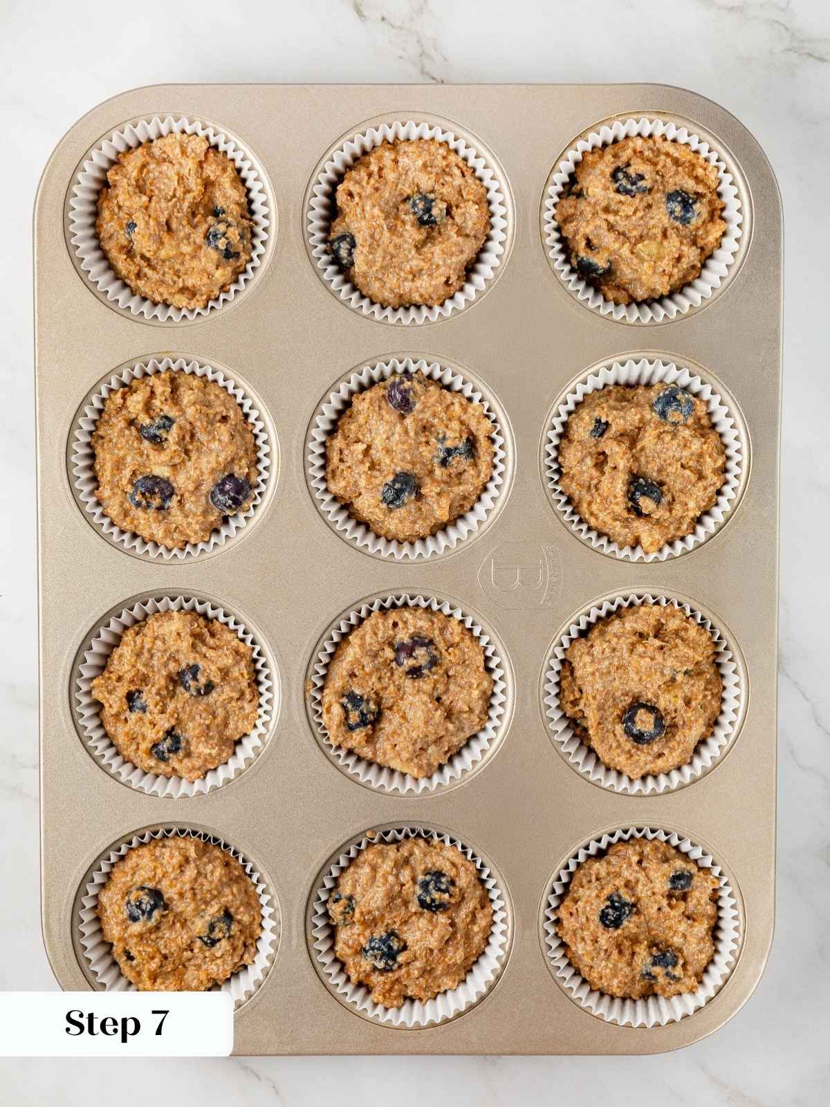Banana protein muffin batter portioned evenly into muffin cups, ready to go into the oven.