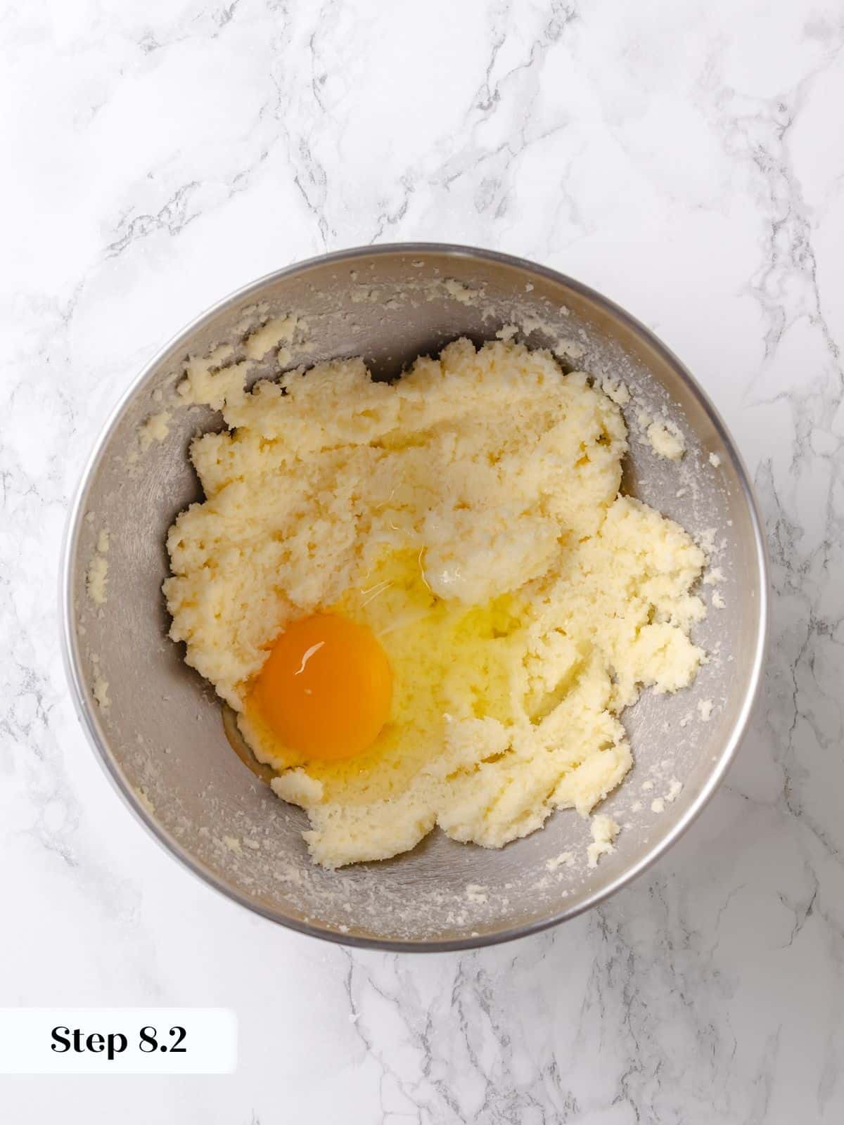 Egg is cracked and stirred into the base mixture for the cake.