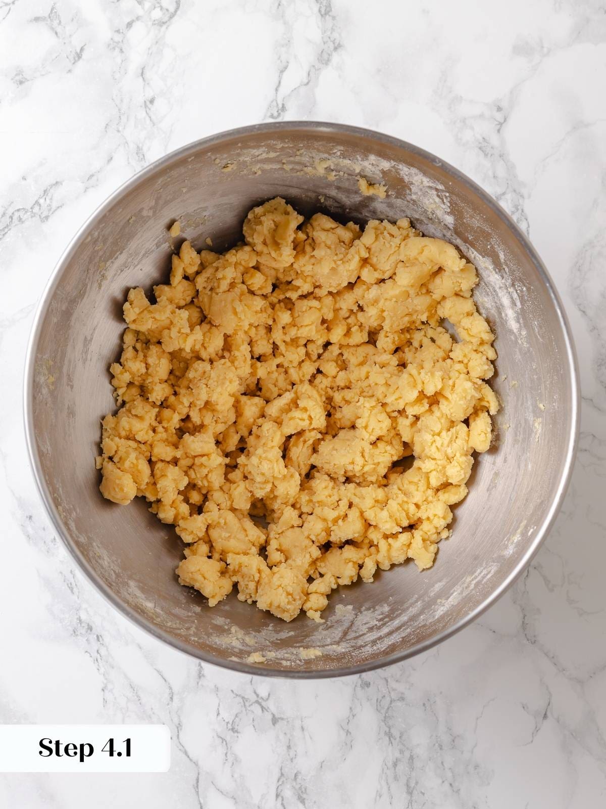Mixing flour into the creamed ingredients during the early stage of cake batter preparation.
