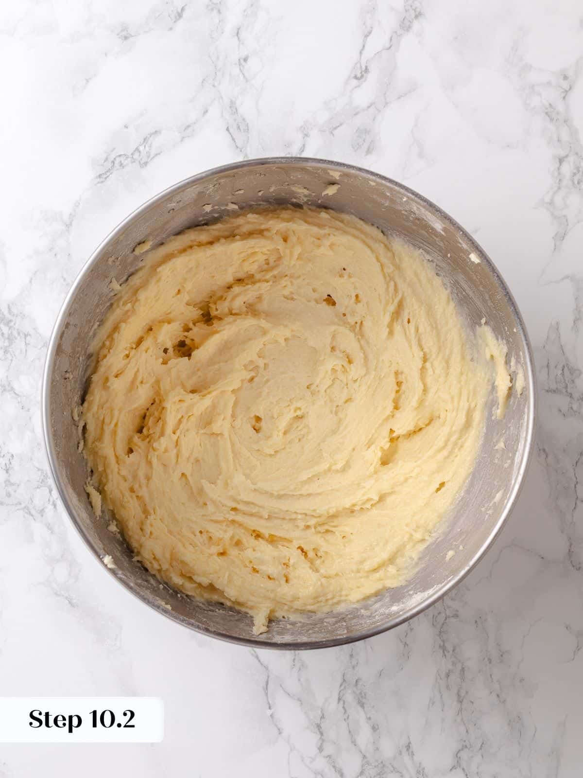 Thick sugar batter is fully mixed and waiting to be spread on the risen cake base.