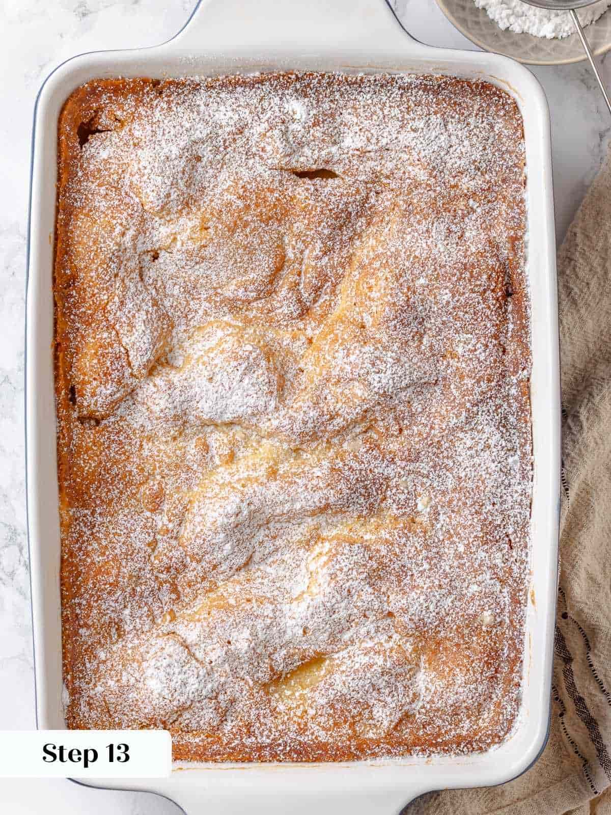 A thick layer of powdered sugar is dusted on top of the baked gooey butter cake.