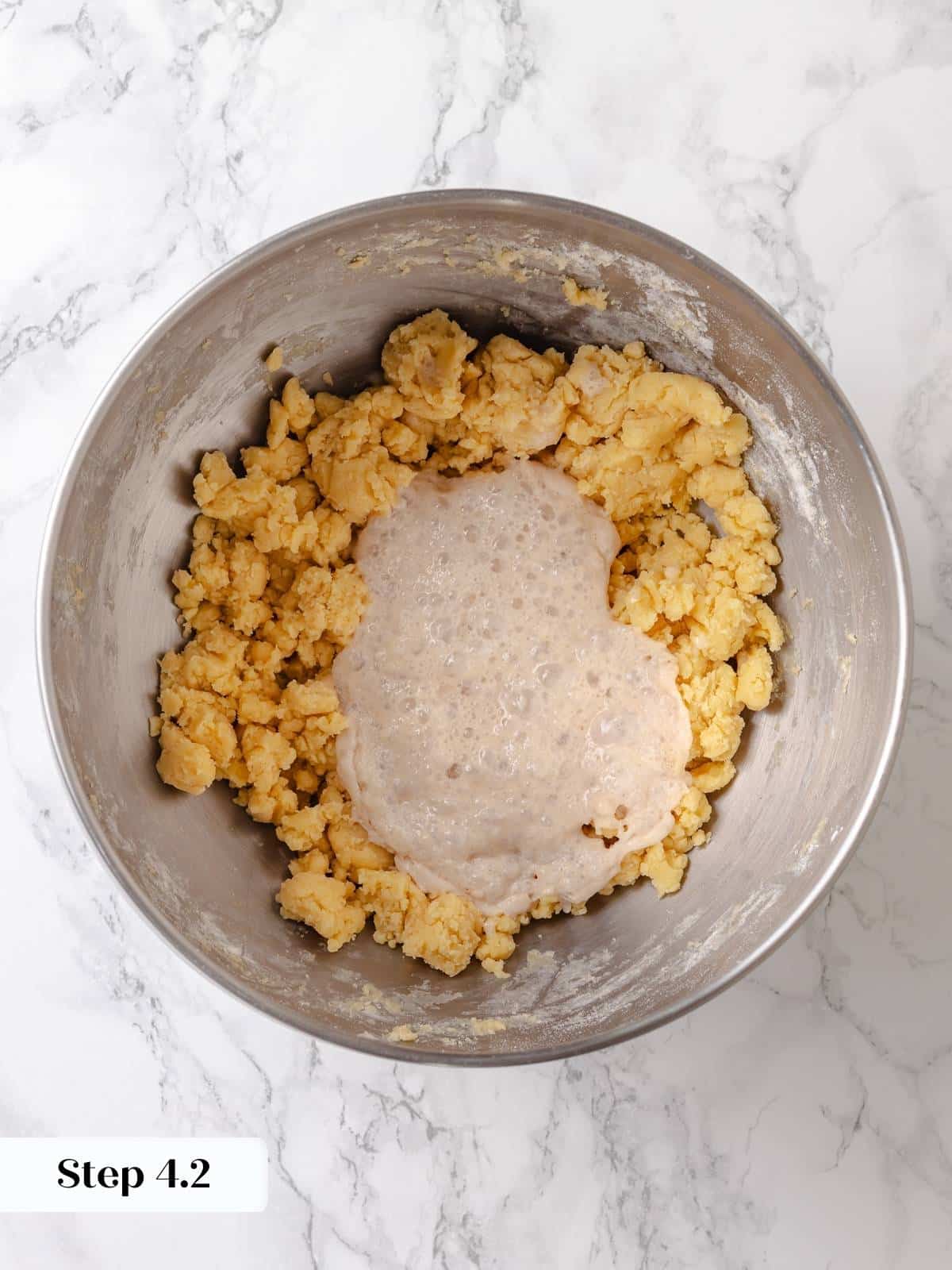 Activated yeast mixture is added to the butter mixture to begin building the dough.