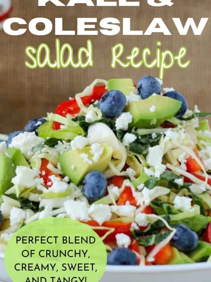 Closeup of Kale & Cabbage salad showing toppings of fresh avocado, blueberries, sliced red bell peppers, and feta cheese.