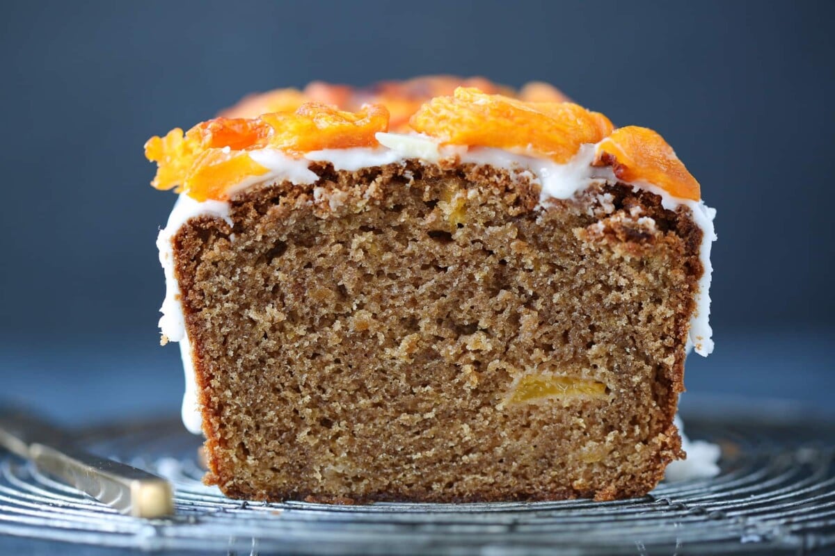 Interior of peach cake showing soft, moist texture with visible peach pieces.