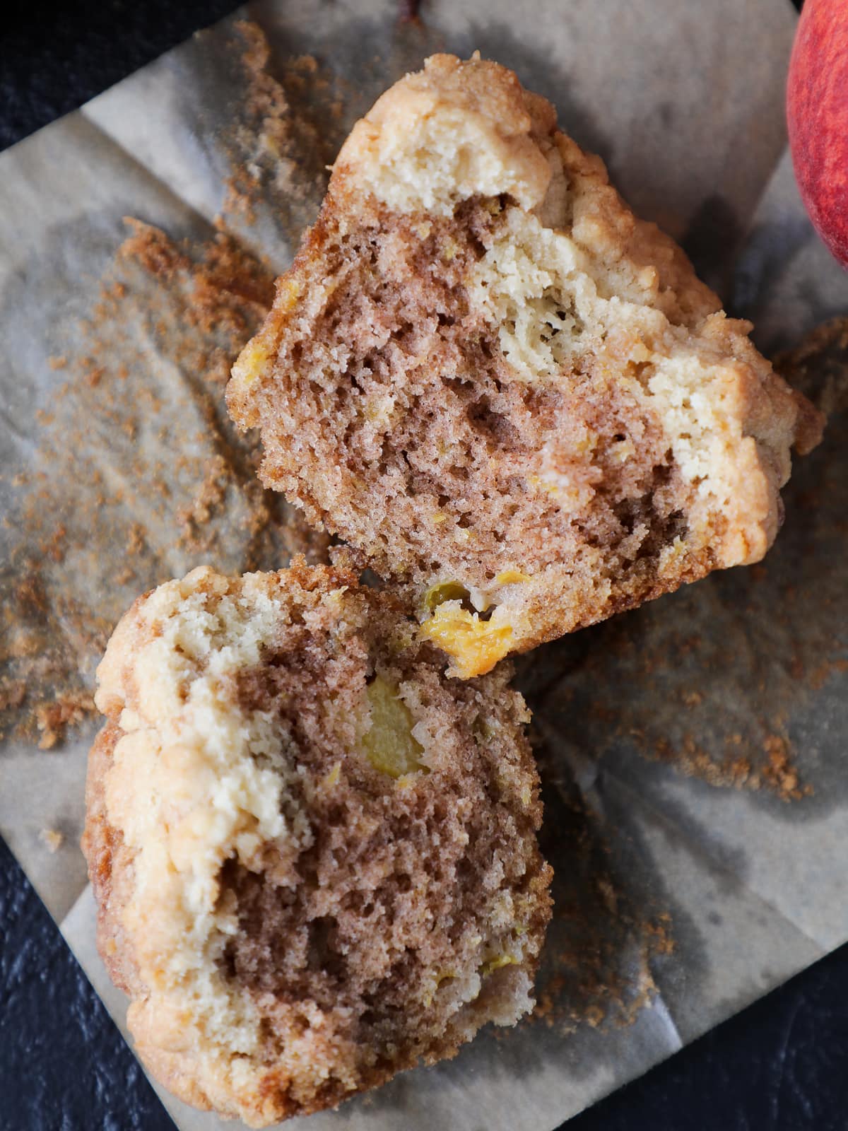 Cut peach muffin with tender crumb and visible chunks of fruit baked into the center.
