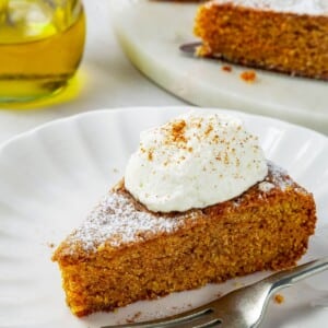 One generous piece of spiced pumpkin cake resting on a plate with fork nearby.